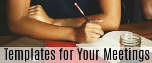 Person writing on a red desk in a notebook