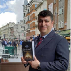 Andrew Zeitoun standing in front of a building