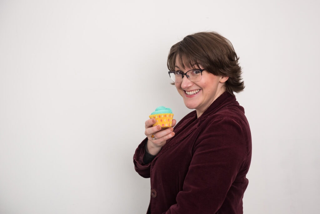 Elizabeth Harrin wearing glasses, with a cupcake