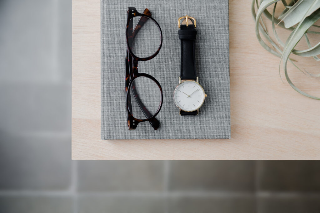 wrist watch and glasses on a desk