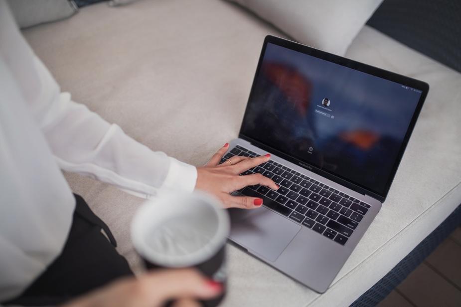 someone standing typing on a laptop