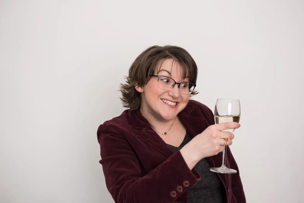 Elizabeth holding a glass of wine
